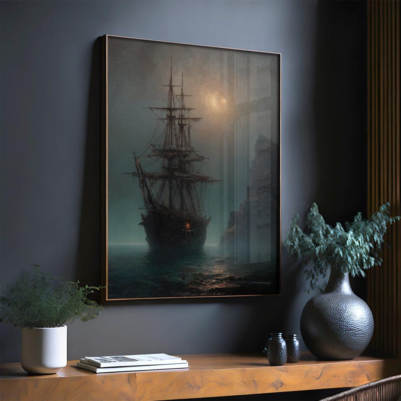 May include: A framed wall art print depicting a dark, multi-masted sailing ship on a misty, dark ocean at night. The scene features a glowing light on the ship's hull, a rocky cliffside to the right, and a faint, hazy moon in the sky.
