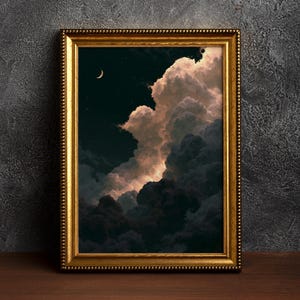 Pode incluir: Uma peça de arte de parede retangular numa moldura dourada ornamentada com um céu noturno escuro, uma lua crescente e estrelas. Grandes nuvens volumosas dominam a composição, iluminadas com luz rosa e branca suave contra sombras profundas.