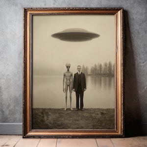 Puede incluir: Impresi&oacute;n enmarcada en tonos sepia que muestra a un hombre con traje junto a un extraterrestre, con un OVNI sobre un lago. La obra de arte est&aacute; en un marco dorado, evocando una est&eacute;tica vintage.