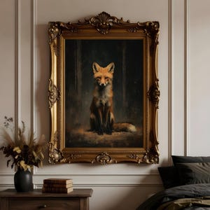 May include: A framed oil painting of a fox. The fox is depicted in a seated position, with a reddish-orange coat and a bushy tail. The painting is set against a dark forest background and is encased in an ornate gold frame.