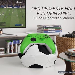 Könnte beinhalten: Ein leuchtend grüner Videospiel-Controller auf einem weiß-schwarzen Fußball-Ständer. Der Text auf dem Bild lautet: DER PERFEKTE HALT FÜR DEIN SPIEL. Fußball-Controller-Ständer. KI-generierte Darstellung.