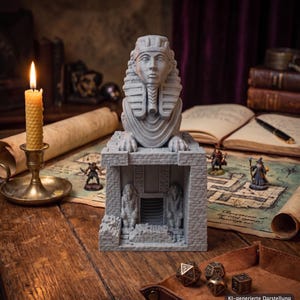 Könnte beinhalten: Eine graue, 3D-gedruckte Sphinx-Statue mit detailliertem Pharaonenkopf und Kopfschmuck, platziert auf einem steinstrukturierten Tempelsockel mit zwei kleineren Statuen, die einen zentralen Eingang flankieren, alles in matter Optik.