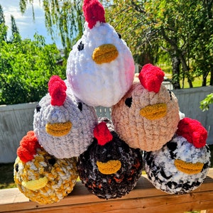 Puede incluir: Seis peluches de pollo de crochet en varios colores, incluyendo blanco, marr&oacute;n, negro y amarillo. Los peluches tienen crestas y barbillas rojas y est&aacute;n dispuestos en forma de pir&aacute;mide.