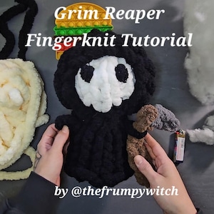 Puede incluir: Una muñeca de la Parca hecha a mano con los dedos, con una cara de calavera blanca, una capucha negra y una guadaña marrón y gris. El texto "Grim Reaper Fingerknit Tutorial" se muestra encima de la muñeca.