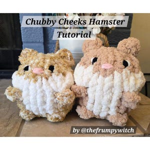 May include: Two plush hamster toys made of soft, textured yarn. Each features a round body with tan and white fur, small ears, black eyes, and a pink nose. The text "Chubby Cheeks Hamster Tutorial" and "by @thefrumpywitch" is overlaid on the image.