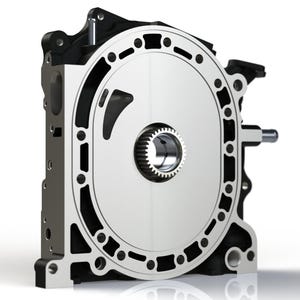 May include: A silver and black rotary engine housing, a mechanical component with a circular design. The engine features a central gear and a series of openings around the perimeter. The background is white.