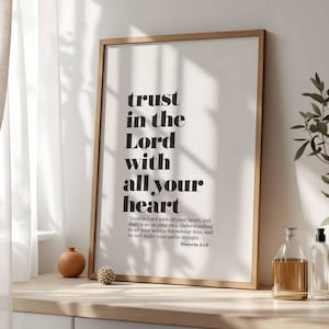 Può includere: Una stampa in bianco e nero incorniciata con il testo "trust in the Lord with all your heart" e un versetto biblico da Proverbi 3:5-6.