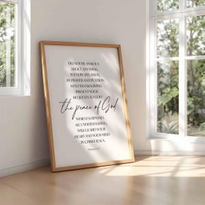 May include: A framed print with a light wood frame. The print features the text "DO NOT BE ANXIOUS ABOUT ANYTHING...the peace of God...IN CHRIST JESUS. Philippians 4:6-7" in black script and block letters on a white background.