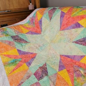 Trapunta patchwork, coperta trapuntata in tessuto batik. Motivo caleidoscopio, copridivano giallo e arancione.