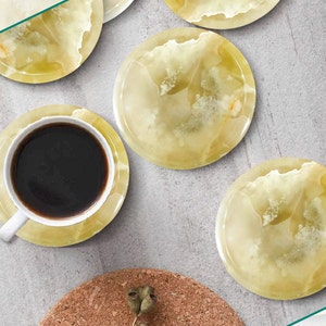 Può includere: Set di cinque sottobicchieri rotondi in onice giallo con un motivo a spirale. I sottobicchieri sono in pietra naturale e hanno una finitura liscia e lucida.