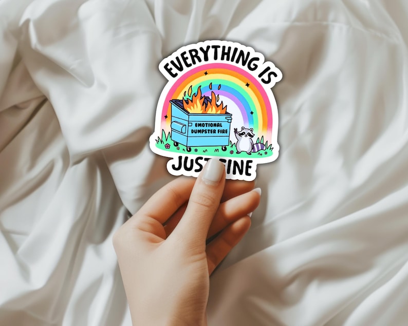 K&ouml;nnte beinhalten: Ein Aufkleber mit einem Regenbogen und einem brennenden M&uuml;lleimer. Der Text lautet "Alles ist gut" und "Emotionales M&uuml;lltonnenfeuer". Ein Waschb&auml;r steht neben dem M&uuml;lleimer.