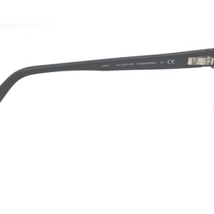 Puede incluir: Gafas negras con montura rectangular y patillas curvas. La patilla tiene el texto "OAKLEY" y otras marcas. Las lentes transparentes est&aacute;n dentro de la montura. Sobre un fondo blanco.