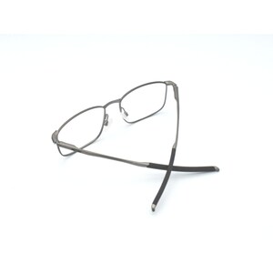 May include: A pair of silver-toned spectacles with black temple tips. The glasses are folded in half and the temple tips are crossed.