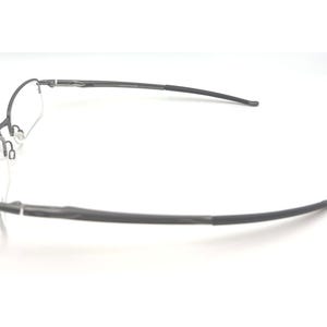 May include: A pair of rimless eyeglasses with a dark gray frame. The glasses have a rectangular lens shape and curved temples. The nose pads are visible. The glasses are set against a white background.