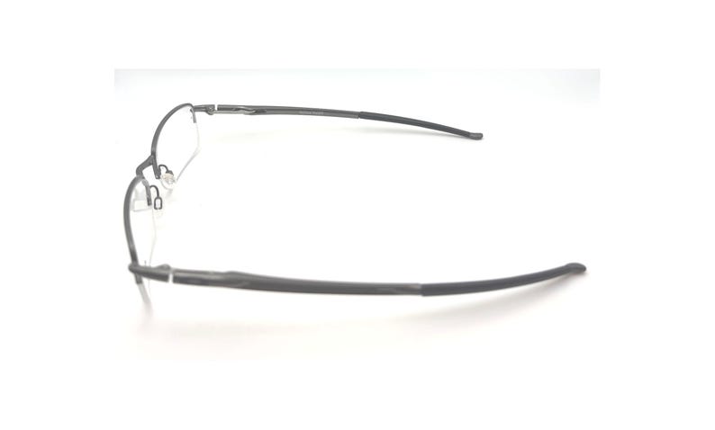 May include: A pair of rimless eyeglasses with a dark gray frame. The glasses have a rectangular lens shape and curved temples. The nose pads are visible. The glasses are set against a white background.
