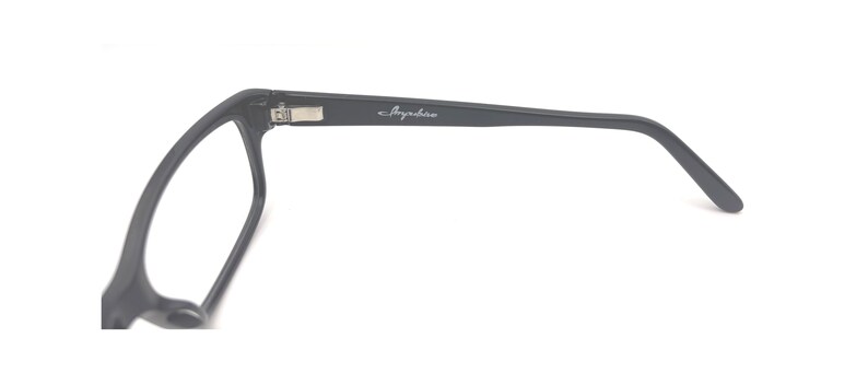 Puede incluir: Gafas negras de forma rectangular, con un dise&ntilde;o minimalista. Las finas patillas llevan el nombre de la marca "Anywhere" en plata. El fondo blanco resalta su elegancia sencilla y discreta.