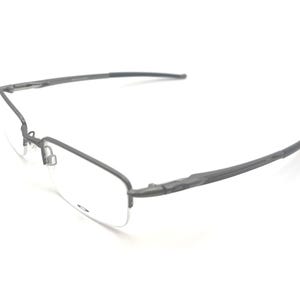May include: Rimless eyeglasses with a dark gray metal frame. The lenses are clear, and the temples curve gently. The glasses are set against a white background, highlighting their minimalist design.