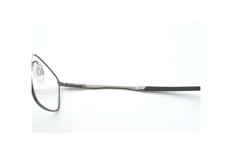 May include: A pair of silver-toned spectacles with black temple tips. The brand name "SAFFIANO" is printed on the temple.