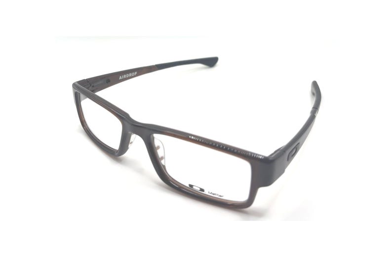 May include: Brown and black rectangular eyeglasses with the word "AIRDROP" on the left arm. The glasses have a dark brown frame and clear lenses. The brand name "Oakley" is visible on the right lens.