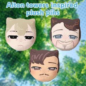 May include: Three plush pins featuring cartoon-style faces with cat ears. The top left pin has light hair, the top right has dark hair and a goatee, and the bottom pin has dark hair and a moustache. The text Alton towers inspired plush pins is visible.
