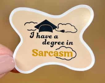 May include: A beige sticker with a white border shaped like a butterfly. The sticker features a black graduation cap with a tassel, two white clouds, and the text "I have a degree in Sarcasm" in black and gold lettering.