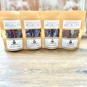 May include: Four brown paper bags with clear windows containing roasted coffee beans. Each bag has a label with the text "The Bad Teacher Company" and a different blend name: "Classroom Walkthrough", "Surprise Faculty Meeting", "Lesson Plans Are Due", and "Maestra Blend".
