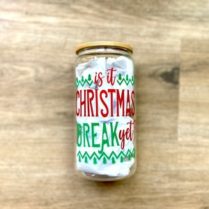 May include: A clear glass jar with a wooden lid and a red and green design that says "is it Christmas break yet".
