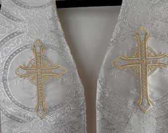 May include: White fabric stole with a silver and gold pattern. The stole features three embroidered crosses with gold trim.