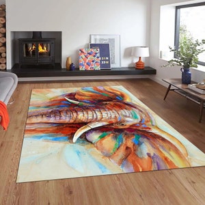 May include: A colorful watercolor painting of an elephant's face. The elephant's trunk is extended and the painting features shades of blue, green, orange, and brown.