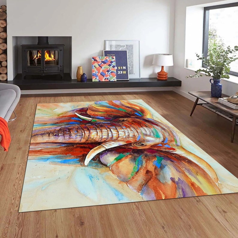 May include: A colorful watercolor painting of an elephant's face. The elephant's trunk is extended and the painting features shades of blue, green, orange, and brown.