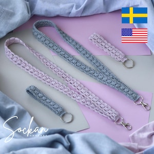 May include: Crocheted lanyards and keychains in gray and lavender. The lanyards have a decorative pattern and metal clasp. The image includes the text "Sockan Crochet".