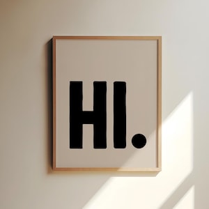 Könnte beinhalten: Ein gerahmter Druck mit dem Wort "HI." in fetten, schwarzen Buchstaben auf beigefarbenem Hintergrund.