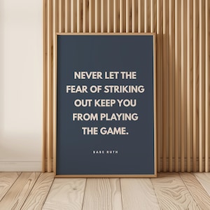 Könnte beinhalten: Ein rechteckiger Wandkunstdruck mit dunkelblauem Hintergrund und hellbeigem Text, der lautet: NEVER LET THE FEAR OF STRIKING OUT KEEP YOU FROM PLAYING THE GAME. Der Name BABE RUTH steht in kleineren hellbeigen Großbuchstaben darunter.