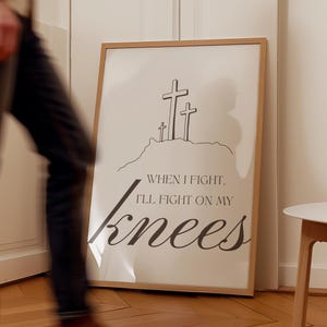 May include: A framed print with a black and white illustration of three crosses on a hill. The text below reads "When I fight, I'll fight on my knees."