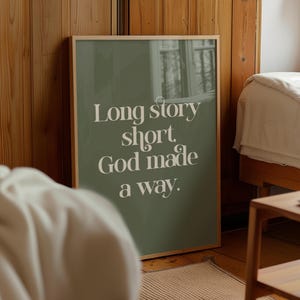 May include: A framed print with a green background and white text that reads "Long story short, God made a way."