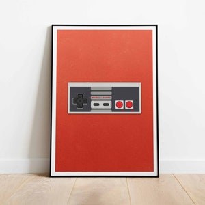 Könnte beinhalten: Ein roter Hintergrund mit einem schwarzen und grauen Videospiel-Controller. Der Controller hat ein Steuerkreuz, zwei Knöpfe und die Aufschrift "SELECT START".
