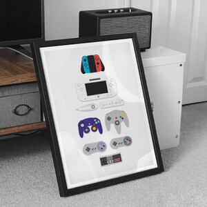 May include: A framed print featuring a collection of video game controllers, including a Nintendo Switch, a Wii U, a GameCube, a Nintendo 64, and a NES controller.