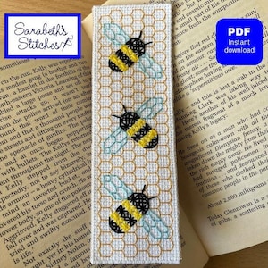 May include: A bookmark with a white background and a honeycomb pattern. Three yellow and black bees are embroidered on the bookmark. The bees are flying in different directions. The bookmark is a cross stitch pattern.