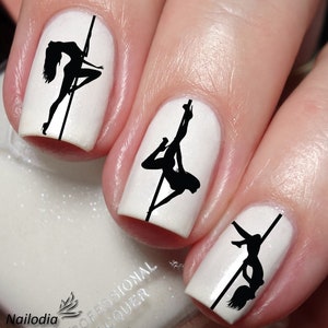 May include: Close-up of fingernails with black silhouette nail art of a woman on a pole. The nail polish is white.