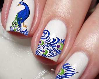 May include: White nail polish with peacock feather designs. The design on the thumb nail features a blue peacock with green and purple accents. The other nails feature a peacock feather design with blue, green, and purple accents.