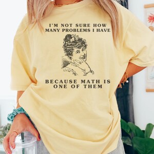 model is wearing Comfort Colors oversized tee shirt in banana (light yellow) with girl math graphic on front