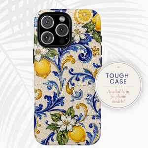 Op de afbeelding: Een telefoonhoesje met een gebarsten crèmekleurige achtergrond en een levendig patroon van gele citroenen, witte bloesems en blauwe en gouden acanthusbladeren. Een ronde badge toont de tekst TOUGH CASE Available in 70 phone models.
