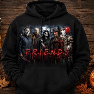 May include: A black hooded sweatshirt featuring a graphic print of five horror movie characters standing together. Below the characters, the word "F.R.I.E.N.D.S." is printed in a red, dripping font. The hoodie has long sleeves and a front kangaroo pocket.
