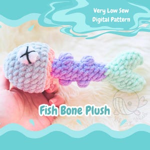 Op de afbeelding: Een gehaakt visgraat pluche speelgoed in tinten lichtblauw, roze en groen. Het speelgoed is gevormd als een visgraat met een groot hoofd en een gevorkte staart. De tekst "Fish Bone Plush" is geschreven in witte letters op een blauwe achtergrond.