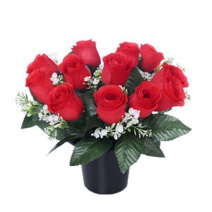 May include: A bouquet of red roses in a black pot. The roses are arranged in a circular pattern and are surrounded by green leaves.