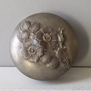 Small vintage circular pewter box with decorative floral lid signed by artist, ornamental pewter pot