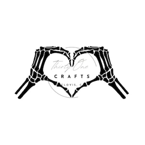 May include: Black and white silhouette of two skeleton hands forming a heart shape. The text "Thirty One Crafts Clovis, CA" is inside the heart.