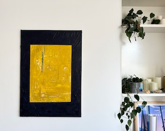 May include: Abstract painting with a yellow and green design framed in black. The painting is hanging on a white wall.