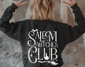 Può includere: Felpa nera con la scritta bianca "Salem Witches Club". Il design include un pipistrello, un ragno, un calderone da strega e una scopa. La persona nell'immagine indossa la felpa e fa il segno della vittoria con le dita.