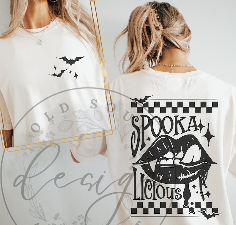 May include: Cream-colored t-shirt featuring a black bat and star design on the front. The back of the shirt displays the words "Spooka Licious" with a vampire mouth graphic, bats, and a checkered pattern, perfect for Halloween.